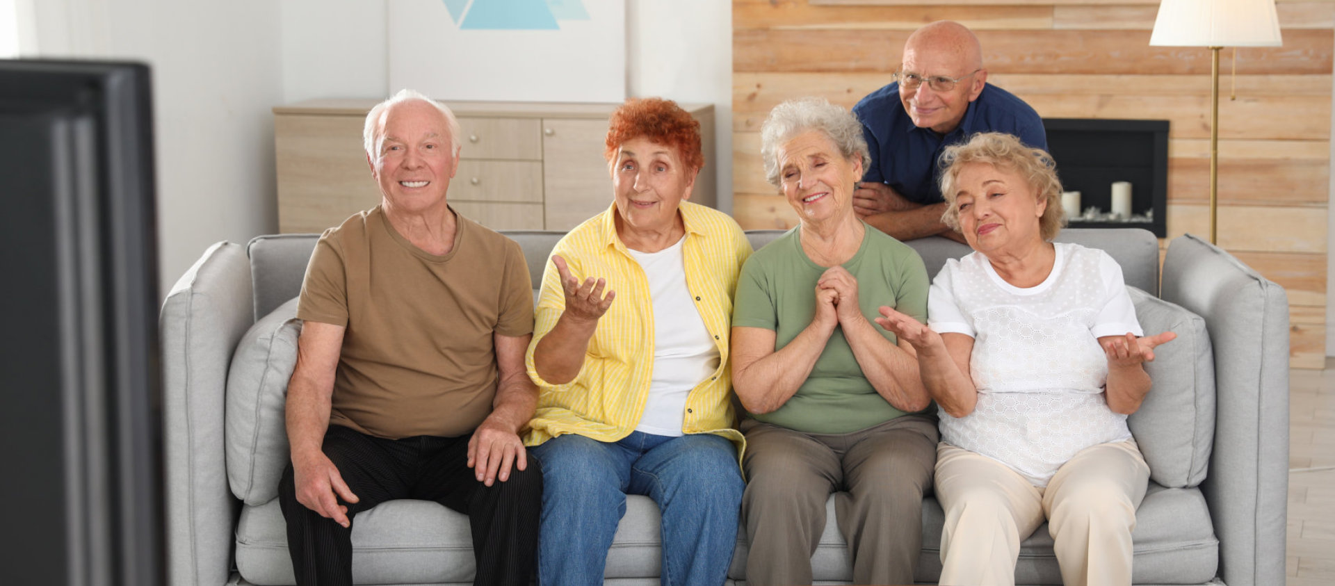 smiling seniors sitting on a sofa